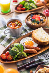 【朝食イメージ】トーストと目玉焼き。ウィンナーとサラダ。ミネストローネとミューズリー。オレンジジュースと牛乳。