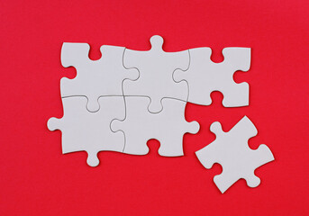 White Puzzle Pieces on Red Background. Missing Piece Concept. Stock photo.