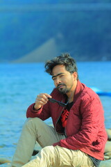 A man was standing near a Lake