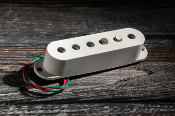 white single coil pickup on black wood background