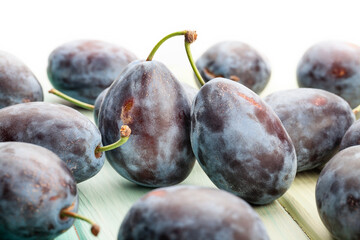 prune plum on wood background on white