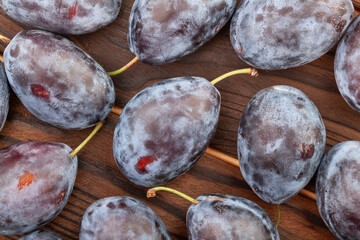 prune plum on wood background top view