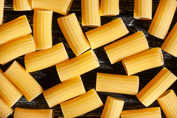 pasta rigatoni on wood background top view pattern texture
