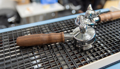 Close-up of espresso machine portafilter with wooden handle