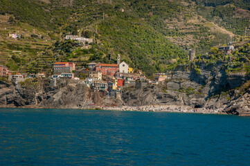 colorful houses on the cliffs and terraced hills of Monterosso al Mare, the northernmost of the five towns of Cinque Terre. The blue waters of the Mediterranean.