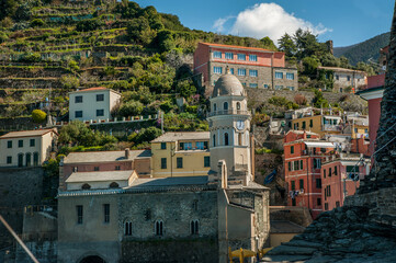 The colorful houses of Vernazza, with its charming church tower and green terraces, form a typical Cinque Terre landscape.