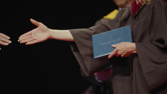 High school graduation ceremony close up diploma handouts proud milestone