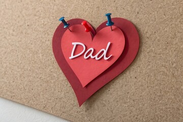 Fototapeta premium Red paper heart with dad message on corkboard