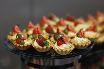 Shortcrust pastry tartlets with cream and strawberries on a plate