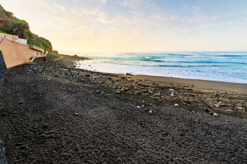 A black volcanic sand beach along the north coast of the Canary Island of Tenerife at the town of Puerto de la Cruz, Spain.