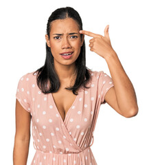 Young Filipino woman in studio showing a disappointment gesture with forefinger.