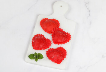 Red Ravioli in the shape of a heart. With cherry filling