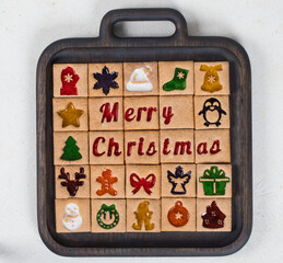 Advent Calendar cookies. 25 Christmas cookies. With colored marmalade filling. On a wooden board. White background. Top view	
