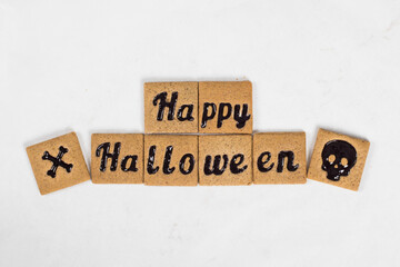Halloween. Cute Cookies with black marmalade in the shape of Happy Halloween and skull, bones....