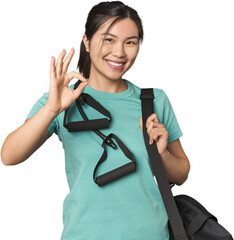 Chinese athlete using resistance bands cheerful and confident showing ok gesture.