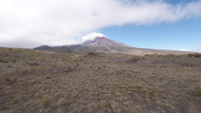 Aerial journey revealing rugged Andean paramo landscape surrounding snow capped Chimborazo volcano, capturing expansive wilderness and geological majesty of Ecuadorian highlands