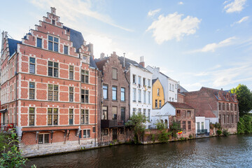 Traditional residential buildings along a river in a city centre under blue sky with clouds at sunset