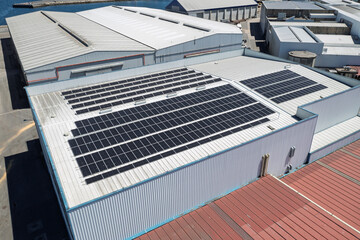 Fototapeta premium Solar panels installed on industrial building roof generating renewable energy