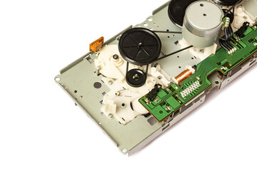 Close-up of the magnetic tape drive mechanism of an old double-cassette tape recorder on a white...