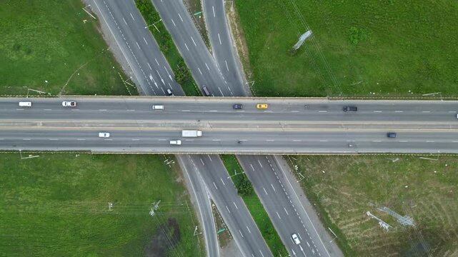 Vista a&eacute;rea de veh&iacute;culos circulando por autopista durante el d&iacute;a. Flujo constante de tr&aacute;fico urbano en carretera moderna con varios carriles.