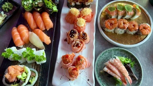 Sushi and rolls in plate. Close-up of sushi rolls on rectangle sushi plate. A set of fresh sushi rolls with salmon, avocado and black sesame seeds served on a plate with chopsticks. Japanese seafood 