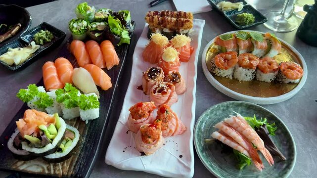 Sushi and rolls in plate. Close-up of sushi rolls on rectangle sushi plate. A set of fresh sushi rolls with salmon, avocado and black sesame seeds served on a plate with chopsticks. Japanese seafood 