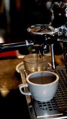 Close up of fresh espresso flows from coffee machine