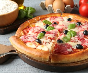 Tasty pizza and ingredients on grey wooden table, closeup
