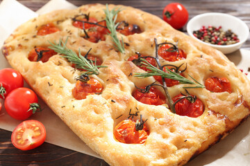 Delicious focaccia with tomatoes and spices on table, closeup