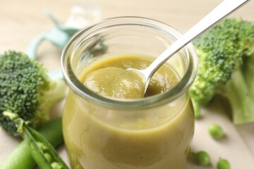 Baby food. Tasty puree in glass jar and ingredients on table, closeup
