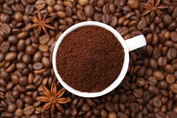 Cup with instant coffee powder and star anise on beans, top view