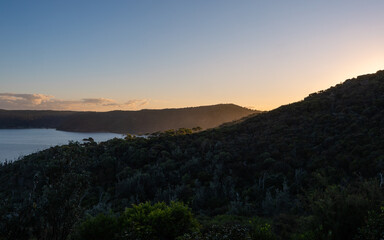 Bay of water with coastal cliff around view.