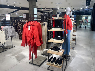 Modern retail store interior showcasing casual clothing and footwear in a stylish, organized layout