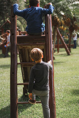 Children Playing on a Wooden Slide in a Park