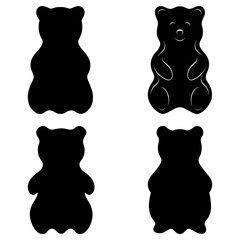 Four gummy bears in silhouette with one having a face and body details on a white background isolated