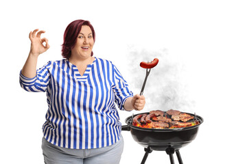 Woman cooking bbq and holding a sausage