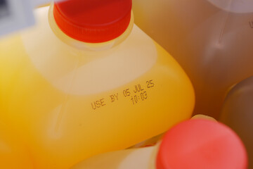 Orange juice containers with expiration date in refrigerator