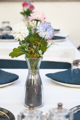 Elegant table arrangement with flowers in clear vase