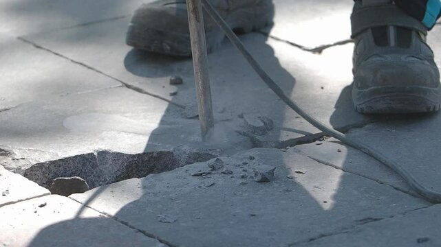 Repairing pavement with a concrete chisel in outdoor setting