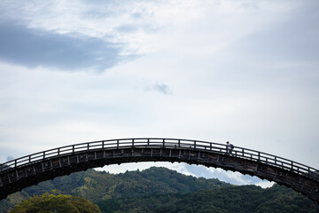 空中に架かる木造橋を渡る旅人 / 山口県岩国市錦帯橋