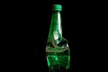 Crushed Plastic Bottle Trash Isolated on Dark Background – Environmental Waste Concept