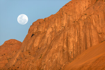 A full moon sets above the Spitzkoppe in Namibia.