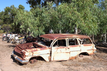Vintage, old, rusty car abandoned in remote Australian Outback, amongst Eucalyptus trees. History, nostalgia, scrap, collection, travel and tourism