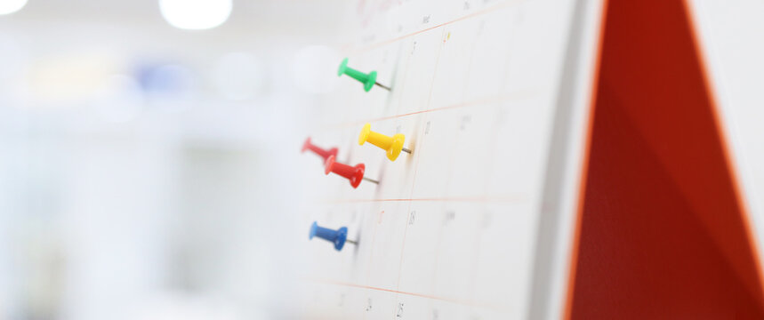 Desk calendar with pins for reminder in office workplace concept of time management agenda event planner or personal organization for business meeting and schedule planning or holiday plan.