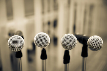A lot of microphones on stand for press conference speaker reports interview or broadcasting public speaking speech presentation stage performance and reporter news.