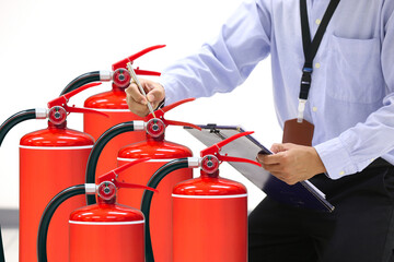 Hand checking fire extinguisher for prevent or prepare fire equipment for prevention in emergency case and safety or rescue and alarm system training concept.