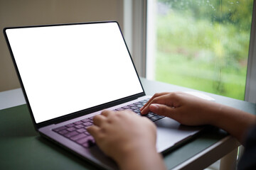 Hands on laptop keyboard, user browsing or working online, blank screen ideal for UI or branding placement.