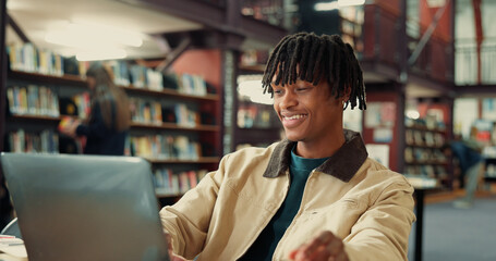 University, happy and man on laptop in library for online assignment, studying and test results. College, academy and student on computer for research, education and learning resources on campus