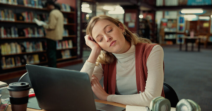 College student, tired and sleeping with laptop in library for study fatigue, burnout or overworked. Education, rest and girl with nap on campus for academic exhaustion, low energy or workload stress