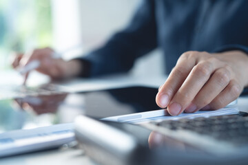 Close up, business woman working on laptop computer with digital tablet on office desk, surfing the internet, searching the information, business background